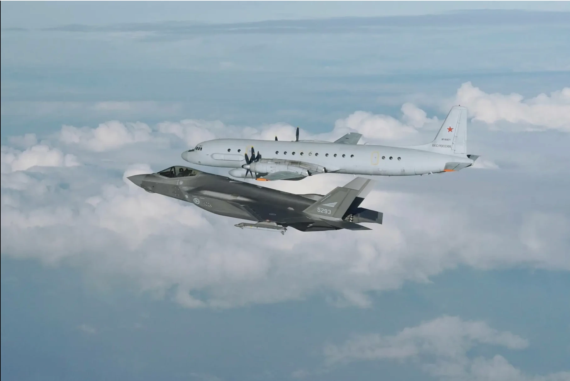 A Russian Il-20 intercepted by a NATO fighter jet over cloud cover
